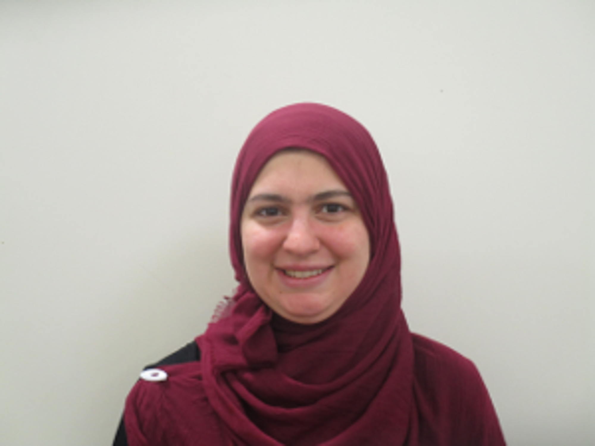 Smiling woman wearing maroon hijab (head scarf)