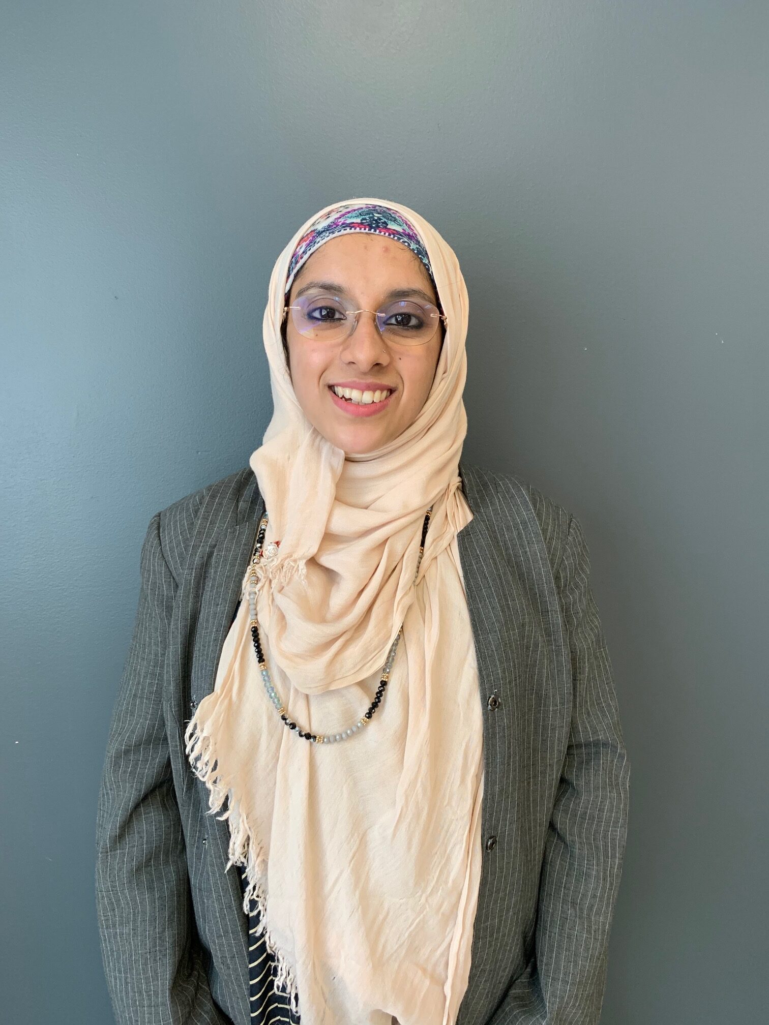 Photo of smiling woman wearing glasses with beige hijab