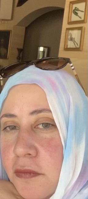 Photo of light complexioned woman wearing white,blue,lavender, and white hijab with sunglasses on top of her head