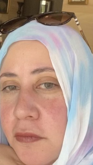 Photo of light complexioned woman wearing white,blue,lavender, and white hijab with sunglasses on top of her head